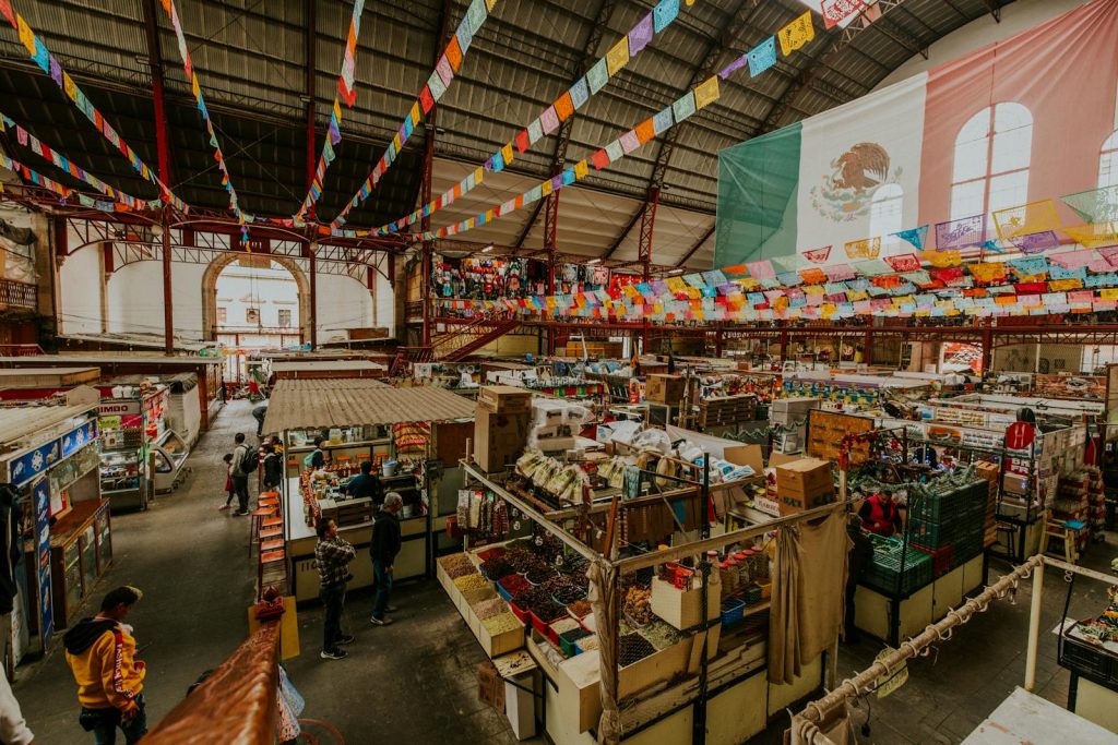 Colorful Mercado Hidalgo in Guanajuato, Mexico. High angle view showcasing vibrant market stalls and Mexican flags.