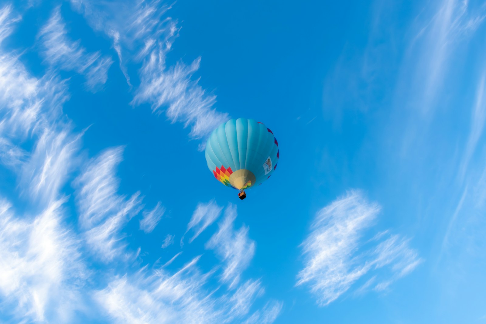a hot air balloon flying through a blue sky
